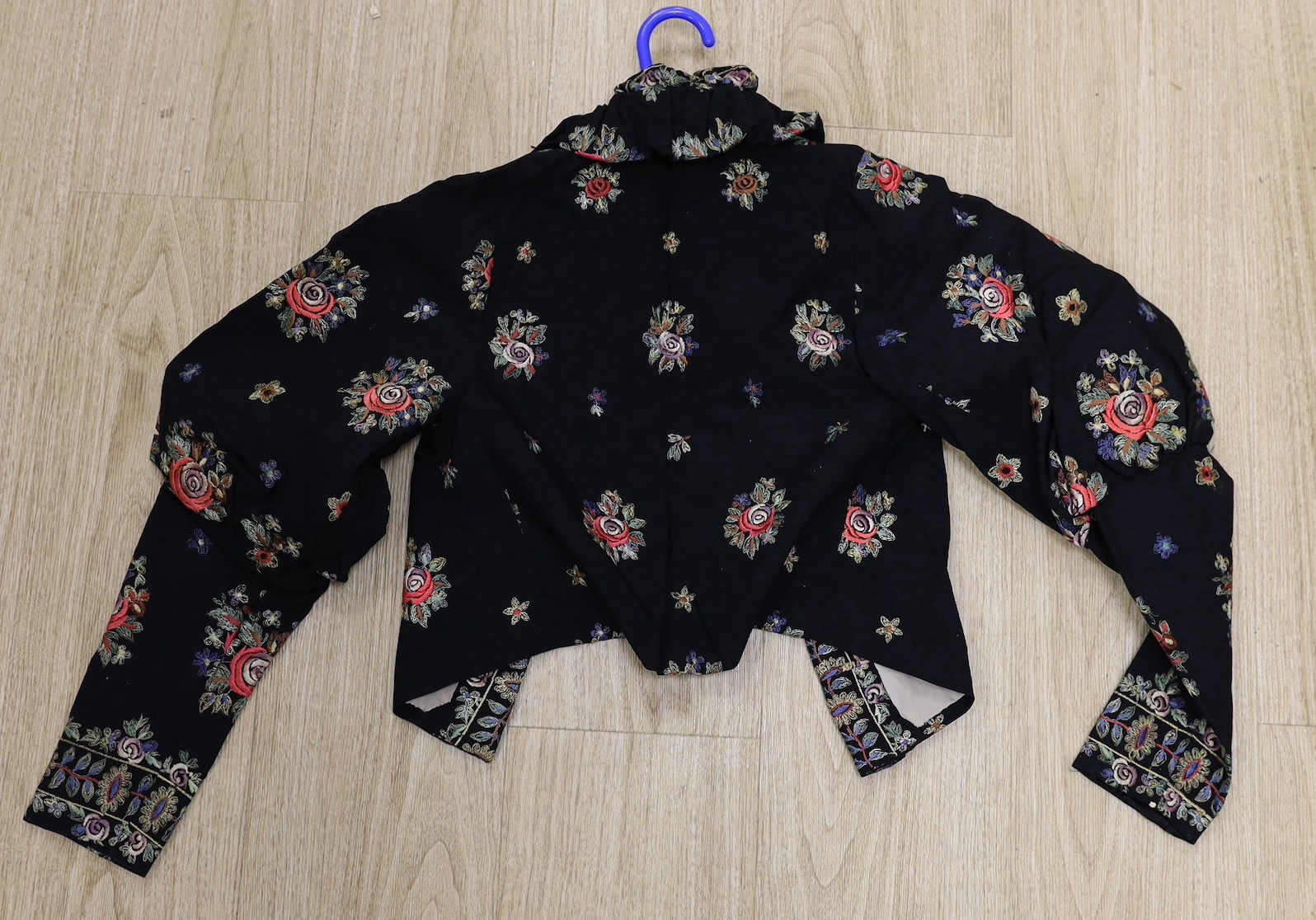 A 1930's-40's black evening jacket, embroidered with multi coloured floral embroidery, together with a blue silk velvet jacket and large bow jabot